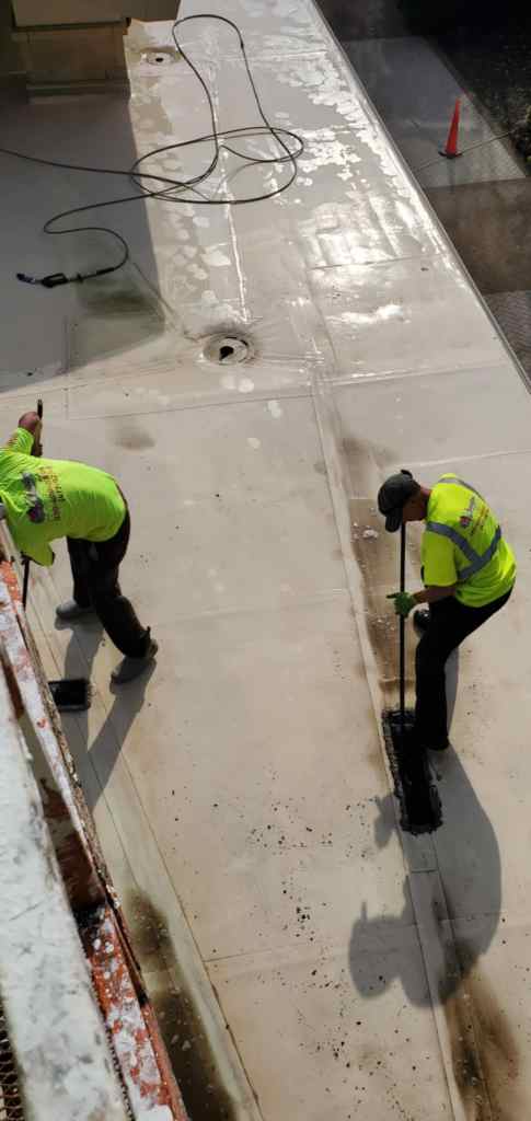 professional pressure washing crew cleaning shopping center walkway