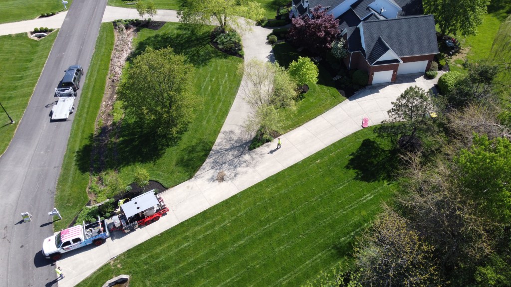 technician using surface cleaner on driveway